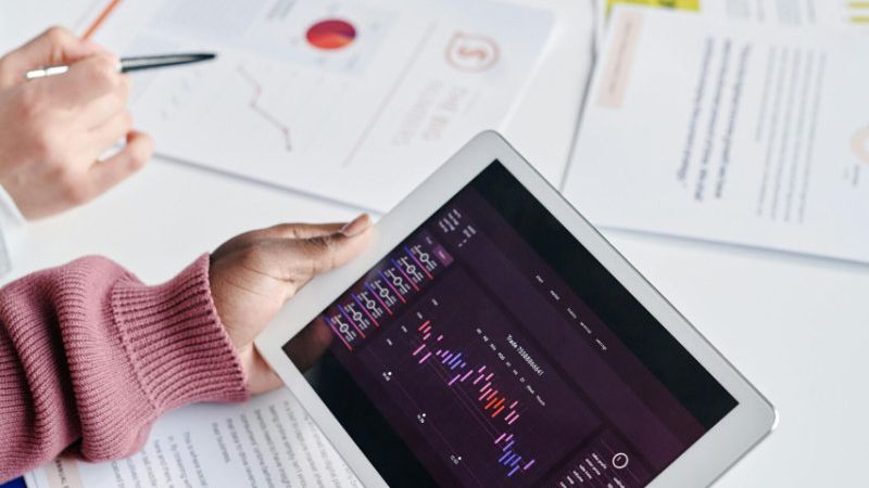 Business appraisal expert looking at charts on a tablet.